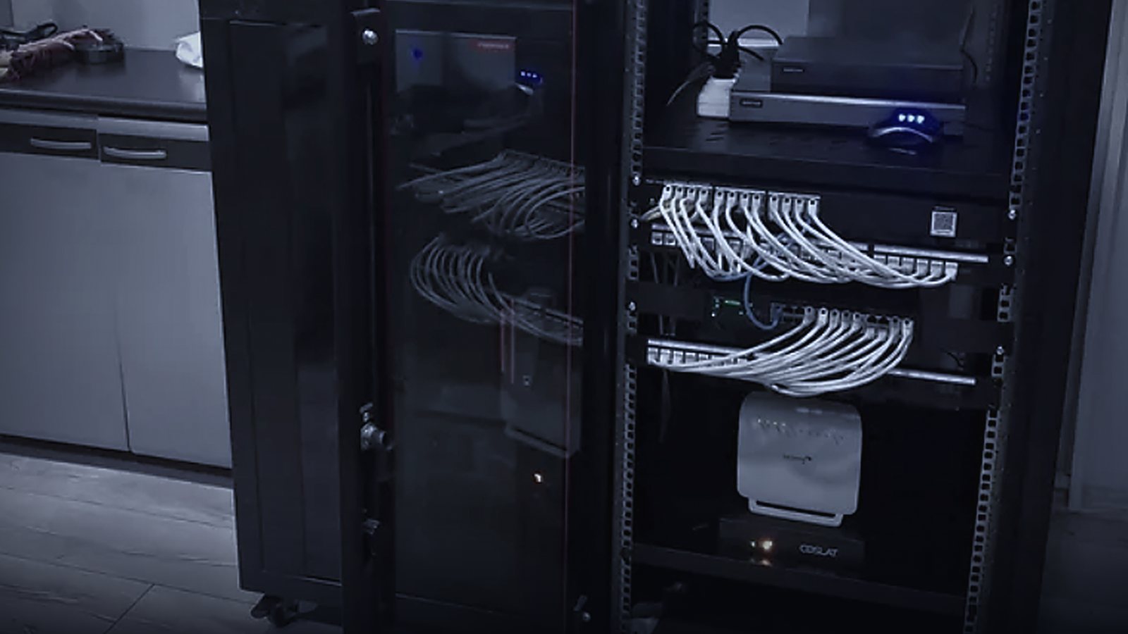 Siyah rack kabin içinde patch panel, switch ve Coslat güvenlik duvarı cihazı