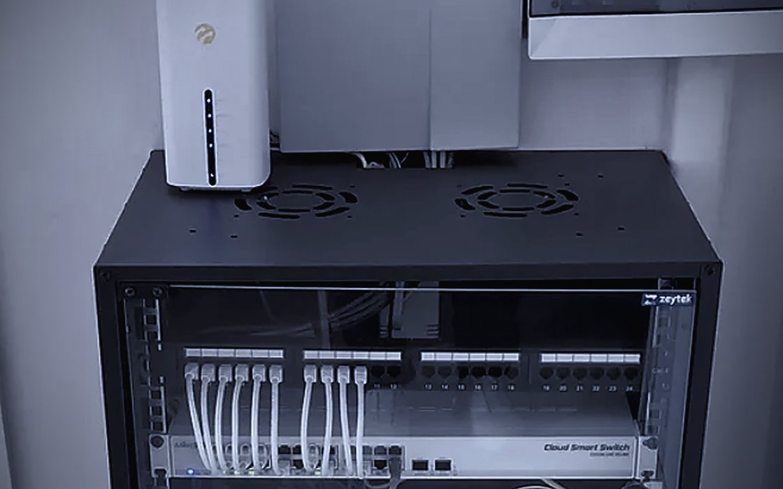 Duvara monte kabin içinde modem, patch panel ve bulut yönetimli switch
